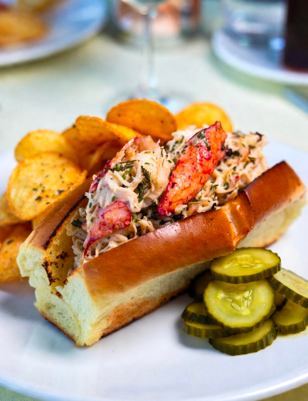 Lobster Roll with Infused with Lemon-Thyme Cannabis Butter, Served with Old Bay Potato Chips and Yuzu-Pickled Cucumbers