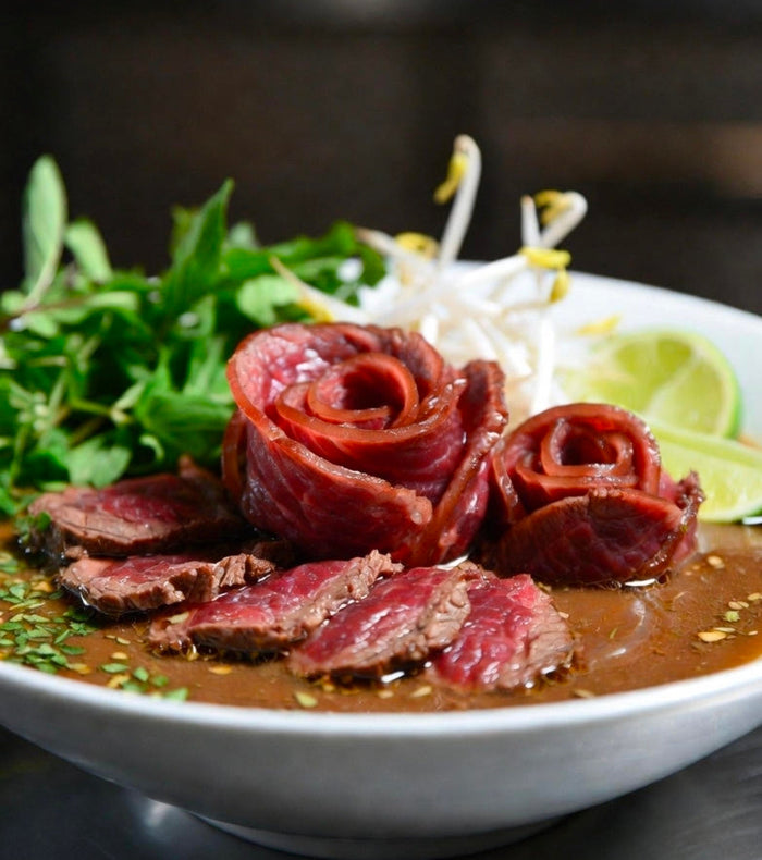 Dry-Aged Ribeye Tomahawk Pho with Infused Bone-Marrow Fat, Rare Beef Roses, and 12-Hour Oxtail Broth